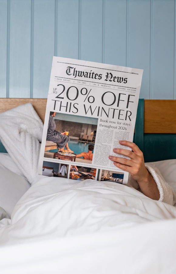 "up to 20% off this winter" newspaper being read by man in hotel bed